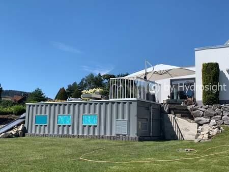 Piscina construida con un contenedor y ventanas Hydrosight