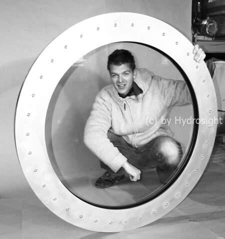 een relatief klein rond raam dat wordt ge&iuml;nstalleerd tussen een visvijver en een zwembad. Het is drukbestendig, zelfs als een van de tanks leeg is.