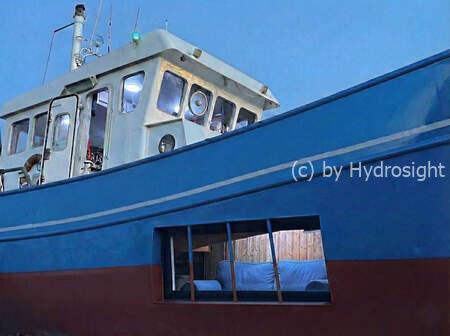 Vissersboot omgebouwd tot rondvaartboot. De boot heeft ramen die gedeeltelijk onder water staan.